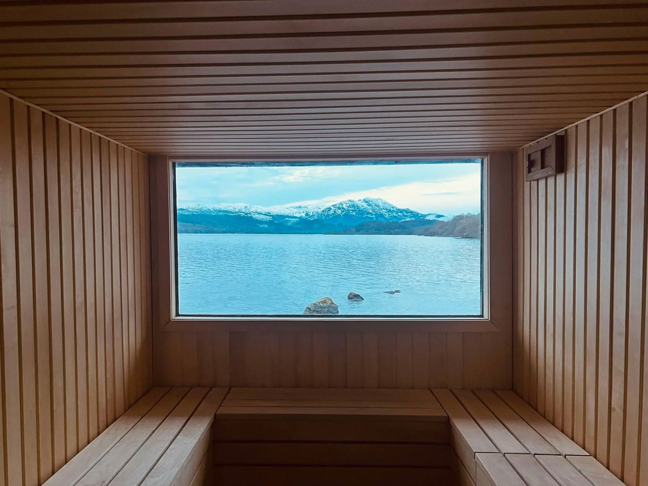Loch and mountain view through the wild sauna picture window